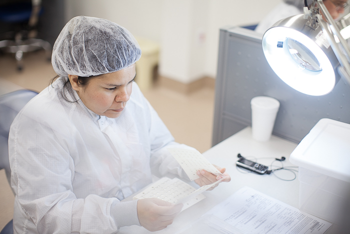 snaptron employee examining metal dome switch arrays