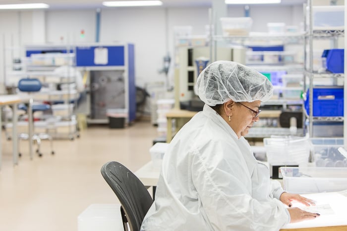 Production worker inspects parts at Snaptron